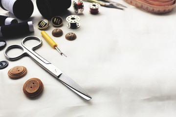 sewing tools on white fabric background. over light, retro tone and high contrast. [blur and select focus background]