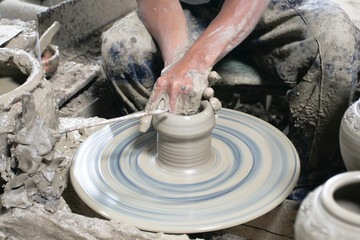 Male hand sculpting pot in pottery