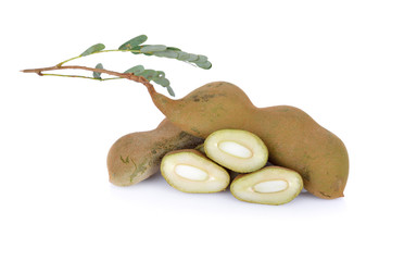 whole and cut young tamarind with leaves on white background