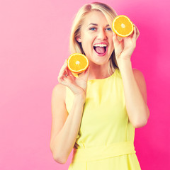 Happy young woman holding oranges