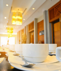 Many  white coffee cups  waiting for  serving with warm light effect,drinking background concept.