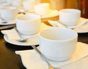 Many  white coffee cups  waiting for  serving with warm light effect,drinking background concept.