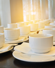 Many  white coffee cups  waiting for  serving with warm light effect,drinking background concept.