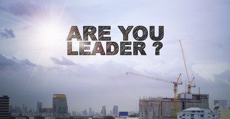 ARE YOU LEADER text on construction building with sky background