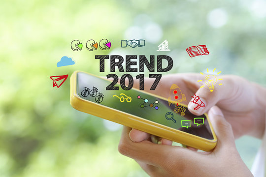 hand holding a smartphone with TREND 2017  concept , business co