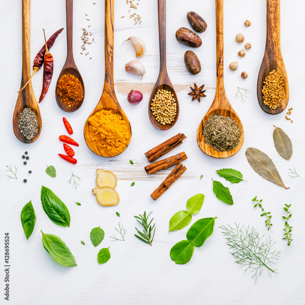 Poster various herbs and spices in wooden spoons. flat lay of spices in