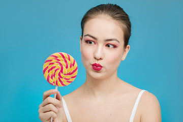 fun girl with candy on blue background