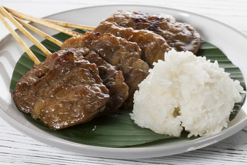 grill pork with sticky rice on wood background