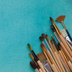 Lots of paintbrushes on colorful canvas background