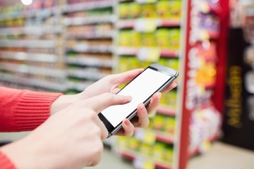 Focus on foreground of woman touching her mobile phone
