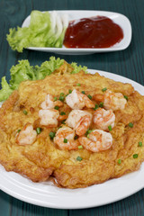 Omelet with shrimp on a wooden table green, thai food