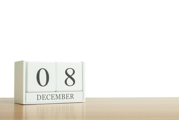 Closeup surface white wooden calendar with black 8 december word on blurred brown wood desk isolated on white background with copy space , selective focus at the calendar
