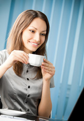 businesswoman with coffee working with laptop at office