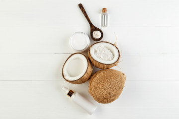 Homemade coconut products on white wooden table background. Oil,