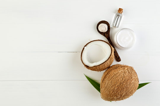 Homemade coconut products on white wooden table background. Oil,