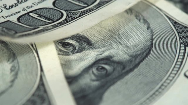 Hundred dollar bills spinning on a table. Close-up