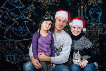 Happy family posing over Christmas background . Merry Christmas