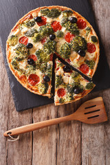 Savory Pie: Sliced Quiche with chicken, broccoli, tomatoes and olives close-up. vertical top view