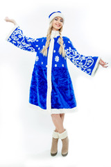 The Snow Maiden in blue Christmas costume. Beautiful white girl with long blond hair braided in pigtails. On her feet wearing suede brown boots. Makeup on the face and blue nails. Isolated on white.