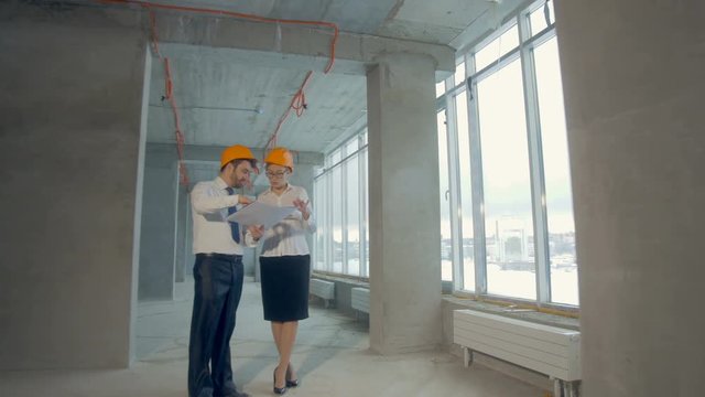 Architect and investor, businesspeople checking new building inder construction. Smooth camera movement, steadycam shot. 4K.