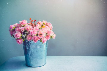 Stii life of pink rose bouquet in pot on table. Vintage filtered