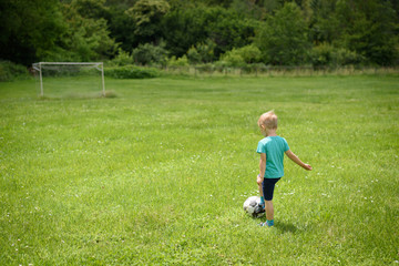 Boy playing football on football pitch