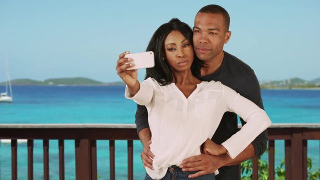 Black couple on vacation in Caribbean taking selfie together