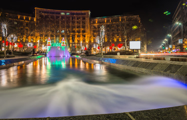 Fototapeta na wymiar Beautiful multicolored square with fountain and NewYear decorati