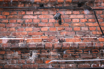 old brick wall of a house with video camera surveillance