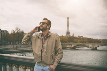 Modern guy using smartphone in the European city.
