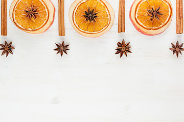 Christmas food - mulled wine background. Decorative frame of spice ingredients -  anise stars, cinnamon, dried oranges and wine on wood white surface. Top view.