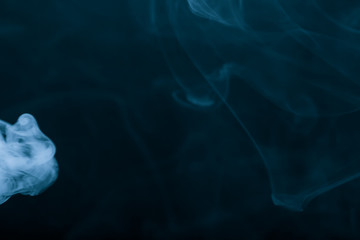 Cloud of smoke on black background. Selective focus. Toned