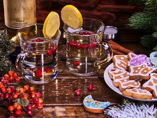Christmas still life with pair mug decoration lemon slice hot drink on wooden table and gingerbread Cookie. Red berries on foreground. Love food concept.