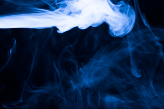 Cloud of smoke on black background. Selective focus. Toned