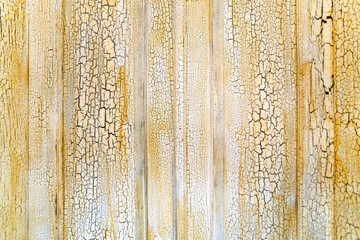 Old wooden surface with cracked white paint and yellow spots, background, texture