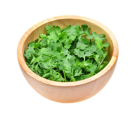 fresh coriander leaves in wooden bowl on white background.