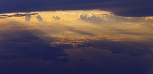 Fototapeta na wymiar Light rays sunset shining through rich in space clouds,panorama