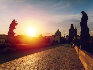 Prague, Czech Republic. Charles Bridge with its statuette at sunrise, Old Town Bridge Tower in the background.