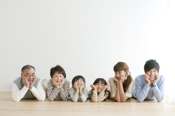 床に寝転ぶ3世代家族