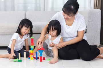 Asian Chinese mother and daughter playing blocks on the floor