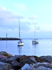 Fototapeta na wymiar Harbor scene with anchored sailing ships at blue hour.