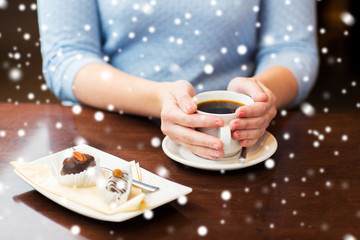close up of woman holding coffee cup and dessert