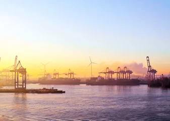 Hafenkräne im Sonnenuntergang oder Sonnenuntergang, Frachtschifffahrt oder Containerhafenszene. © eivaisla