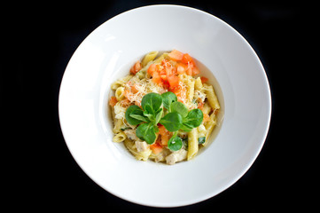 pasta with vegetables and cheese in white plate and black background