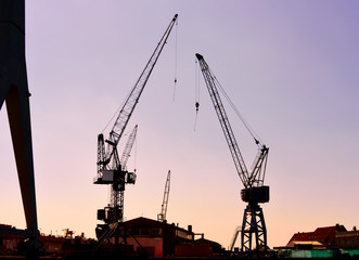 Harbor cranes in the sunset or sundown, freight shipping or container harbor  scene.