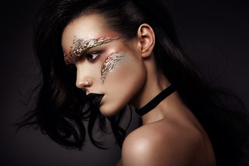 Beautiful woman with bronse futuristic make up