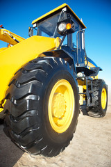 Bright yellow tractor on the background of blue sky