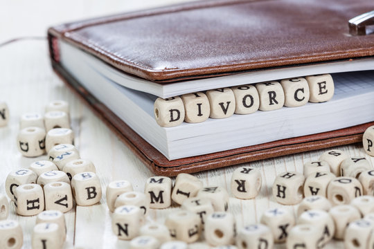Word DIVORCE on old wooden table.