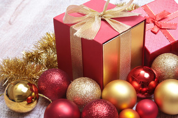 Fototapeta na wymiar Gift boxes with many christmas balls on wood background