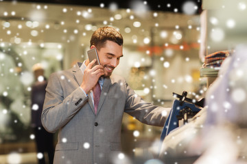 happy man calling on smartphone at clothing store